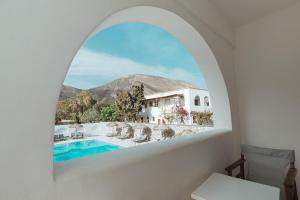 a room with a view of a pool and a house at Hotel Marybill in Perissa