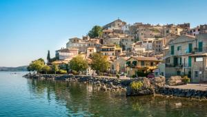 a group of houses on a hill next to a body of water at Hotel Massimino in Anguillara Sabazia