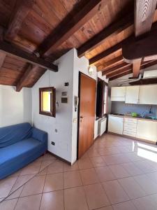 a living room with a blue couch and a kitchen at Dante 12 Flat in Cremona