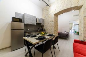 a kitchen and living room with a table and a refrigerator at Salerno Mare e Luci Suite in Salerno