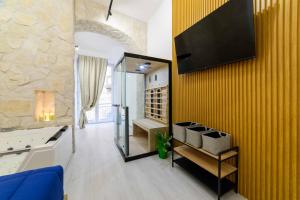 a living room with a tv on a yellow wall at Salerno Mare e Luci Suite in Salerno