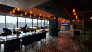 a restaurant with tables and chairs and a view of the ocean at Plume Hotels, India Expo Mart, Greater Noida in Greater Noida