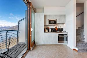a kitchen with a balcony with a view of the mountains at Vista 180 by Halldis in Perledo