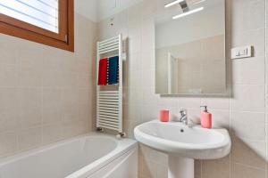 a white bathroom with a sink and a bath tub at Vista 180 by Halldis in Perledo +22 photos