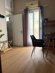 a black chair in a room with a door at BYZANTIUM APARTMENTS in Ermoupoli