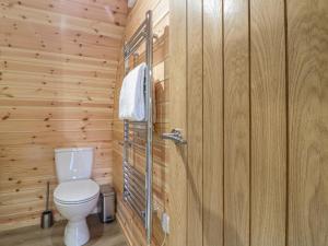 a bathroom with a toilet in a wooden wall at Park View Lodge in Derby +14 photos