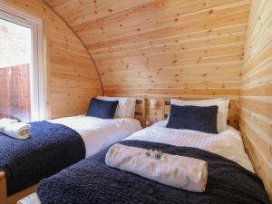 a bedroom with two beds in a log cabin at Park View Lodge in Derby