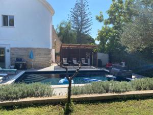 a pool in the backyard of a house at Pink Moon Private Luxury Villa Secluded Garden 5 Bedroom 4 en suite Bathrooms with Private Pool CAT 6 WiFi Close to Beach in Fontane Bianche