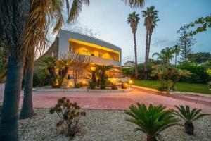a large house with palm trees in front of it at Pink Moon Private Luxury Villa Secluded Garden 5 Bedroom 4 en suite Bathrooms with Private Pool CAT 6 WiFi Close to Beach in Fontane Bianche