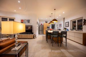 a kitchen and living room with a couch and a table at Pink Moon Private Luxury Villa Secluded Garden 5 Bedroom 4 en suite Bathrooms with Private Pool CAT 6 WiFi Close to Beach in Fontane Bianche