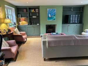 a bedroom with a bed and a couch and chairs at Riverside Cottage in Marlborough