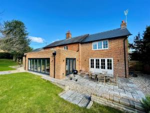 an image of a brick house with a patio at Riverside Cottage in Marlborough