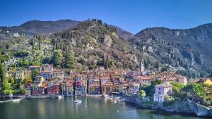 a town on a river with mountains in the background at Varenna Boulevard in Varenna
