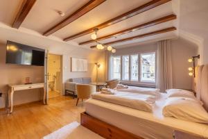 a bedroom with two beds and a living room at the eighteen86 by keyone in Bad Gastein