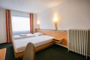 a hotel room with a bed and a radiator at Klindworths Gasthof in Sauensiek
