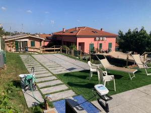 a garden with two chairs and a stone patio at Casa Vacanze immersa tra le colline, appartamento, vicinissima al mare e con nuova piscina in Senigallia