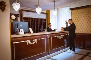 a man in a suit standing at a cash register at Hotel Integra Banja Luka in Banja Luka