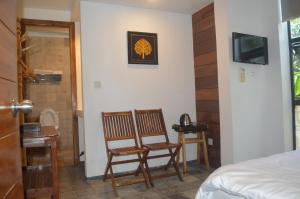 a room with two chairs and a bed and a television at Ruda Mini Hotel in Phumi Ta Phul