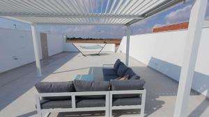 a balcony with a couch and a hammock on a roof at Villa Hermana Major Luxury Villa in Las Flamencas in San Javier