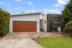 a white house with a brown garage door at Guesthouse on Grampian in Cowes