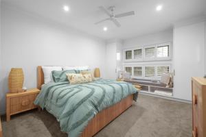 a bedroom with a bed with a green comforter at Guesthouse on Grampian in Cowes
