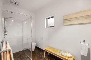 a bathroom with a shower and a toilet and a bench at Guesthouse on Grampian in Cowes +16 photos