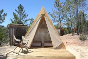 a chair sitting in front of a tent at Parque da Mina in Monchique