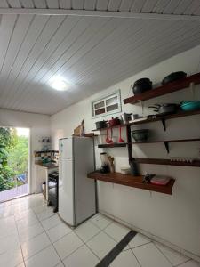 a kitchen with a refrigerator and shelves in it at Casa Canto Verde in Itacaré