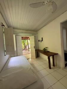 a bedroom with a bed and a table in it at Casa Canto Verde in Itacaré