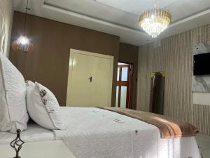 a bedroom with a white bed and a chandelier at M & J Executive Suites in Johannesburg