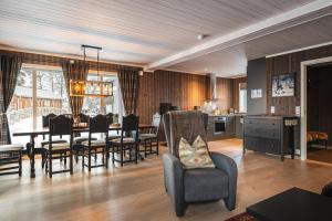 a living room with a table and chairs and a kitchen at Harmony in Geilo, modern and cozy cabin in Geilo