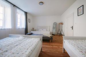 a white bedroom with two beds and a window at Stodola Lesůňky in Lesŭňky