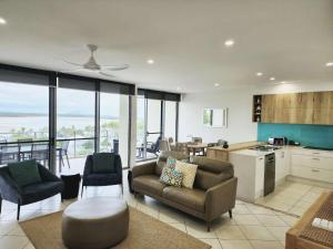 a living room with a couch and a kitchen at The Dunes Cotton Tree in Maroochydore