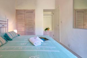 a bedroom with a blue bed with towels on it at Villa K1- INFINITYHOLIDAYS in Costa Paradiso