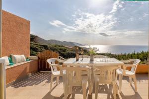 a table and chairs on a patio with a view of the ocean at Villa K1- INFINITYHOLIDAYS in Costa Paradiso
