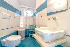 a blue and white bathroom with a toilet and a sink at Villa K1- INFINITYHOLIDAYS in Costa Paradiso +16 photos