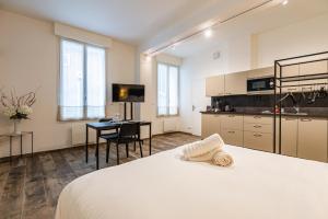 a bedroom with a white bed and a desk at suite Tirelire, centre et paisible in Reims