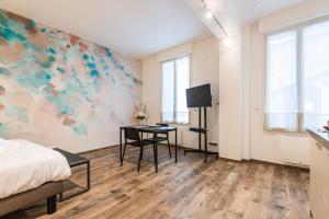 a bedroom with a bed and a desk with a tv at suite Tirelire, centre et paisible in Reims