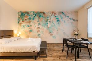 a bedroom with a bed and a desk and a painting at suite Tirelire, centre et paisible in Reims