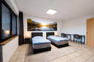 a bedroom with two beds and a painting on the wall at Gästehaus Ferienwohnung Wohnung#3 Jülich in Jülich