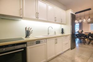 a kitchen with white cabinets and a sink at Daedalus Luxury Home - Seaview & Heated Pool in Kontokali