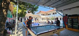 a group of men playing a game of billiard at Apatuxay Vientiane Hostel in Vientiane
