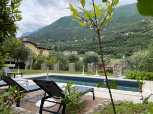 a swimming pool with two chairs next to a house at Villa Gaia Apartments pool wifi parking in Malcesine