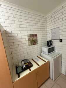 a small kitchen with a microwave and a refrigerator at Budget Motel in Midland Junction