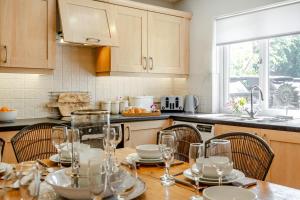 a kitchen with a table with wine glasses on it at 3 Bed in Beadnell oc-44965 in Beadnell +11 photos