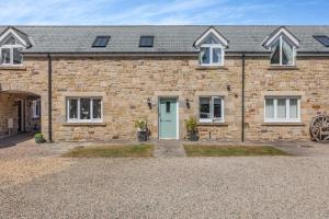 a brick house with a green door and a driveway at 3 Bed in Beadnell oc-44965 in Beadnell