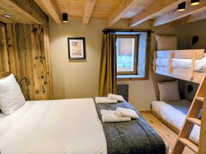 a bedroom with two bunk beds and a window at Les Airelles by Lodji in Saint-Marcel