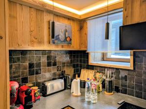 a kitchen with wooden cabinets and a counter top at Les Airelles by Lodji in Saint-Marcel