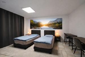 a room with two beds and a table and a painting at Gästehaus Ferienwohnung Wohnung#3 Jülich in Jülich