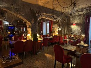 a restaurant with red chairs and tables in a room at Auberge de la Paix in Briançon